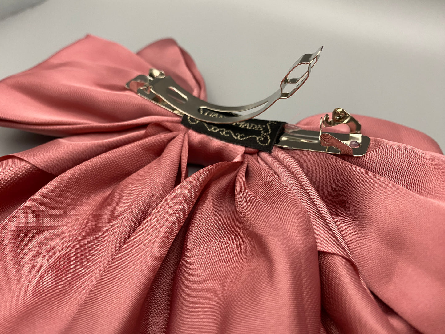 “The Amy Oversized Hair Bow in Pink, crafted from high-quality satin with an oversized bowknot design. Features a minimalist spring clamp for a secure fit. Perfect for stylish updos, daily wear, and special occasions.”