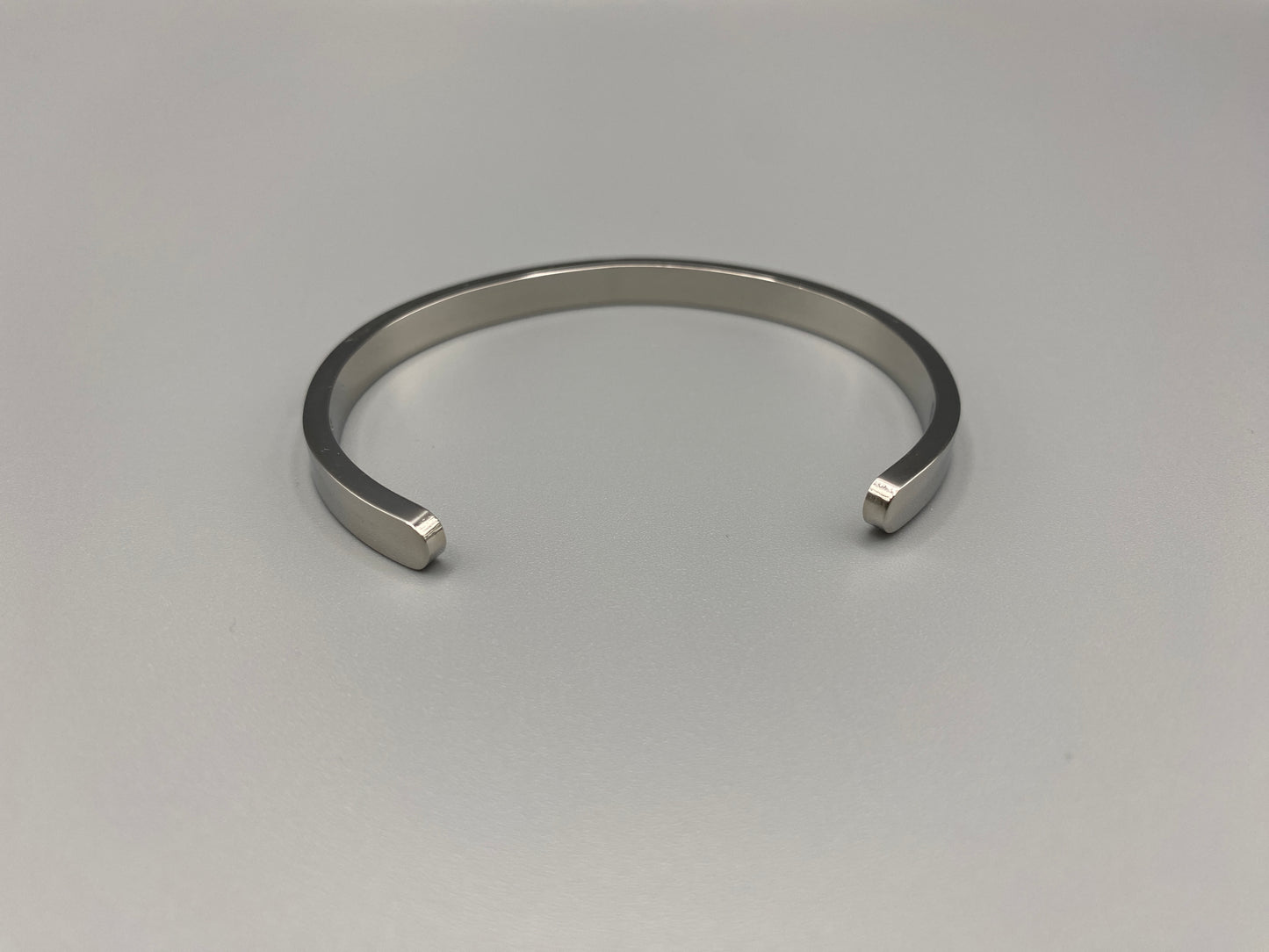 “Lucy Bangle in silver with silver plating and gemstone inlay, offering a radiant and luxurious finish. Durable construction ensures long-lasting wear and tarnish resistance. Perfect for both