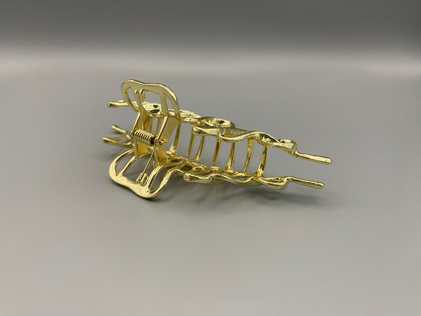 “The Luxe Claw Clip Metal Lightning in Gold, crafted from high-quality, durable metal. Measures 11 cm, featuring a luxurious gold finish and unique link design. Perfect for securing various hair types and styles, suitable for both everyday wear and special occasions.”