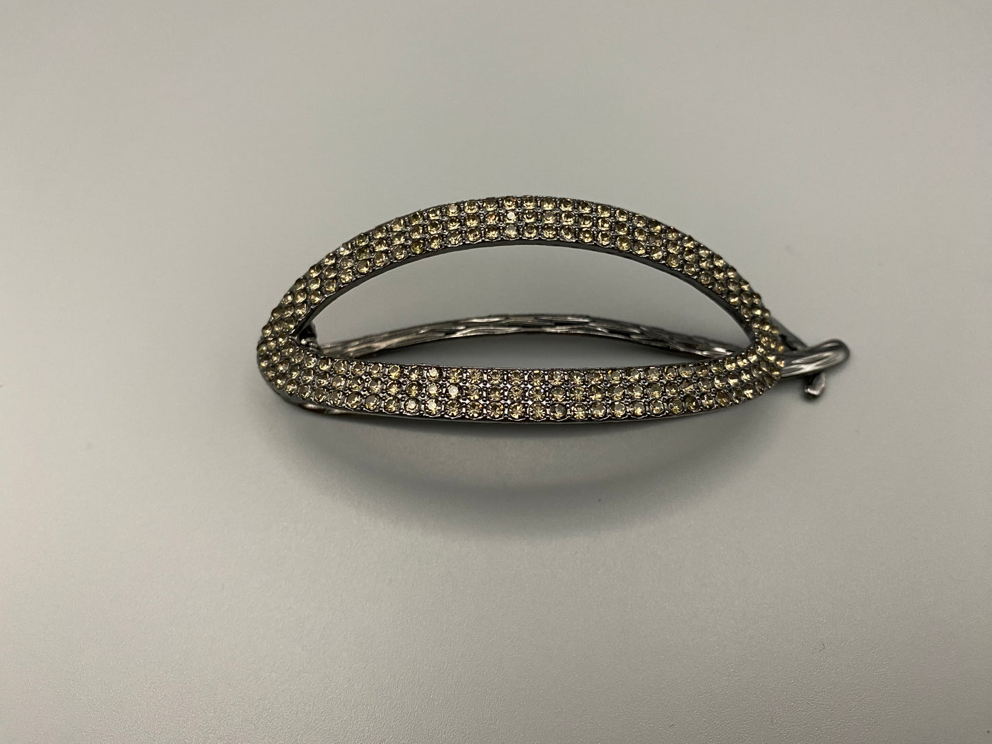 “The Missy Hair Clip, crafted from high-quality metal with sparkling zircon inlaid stones. Features a delicate curved design, measures 9 cm in length, and is perfect for securing various hair types and styles. Durable and luxurious, ideal for effortless beauty.”