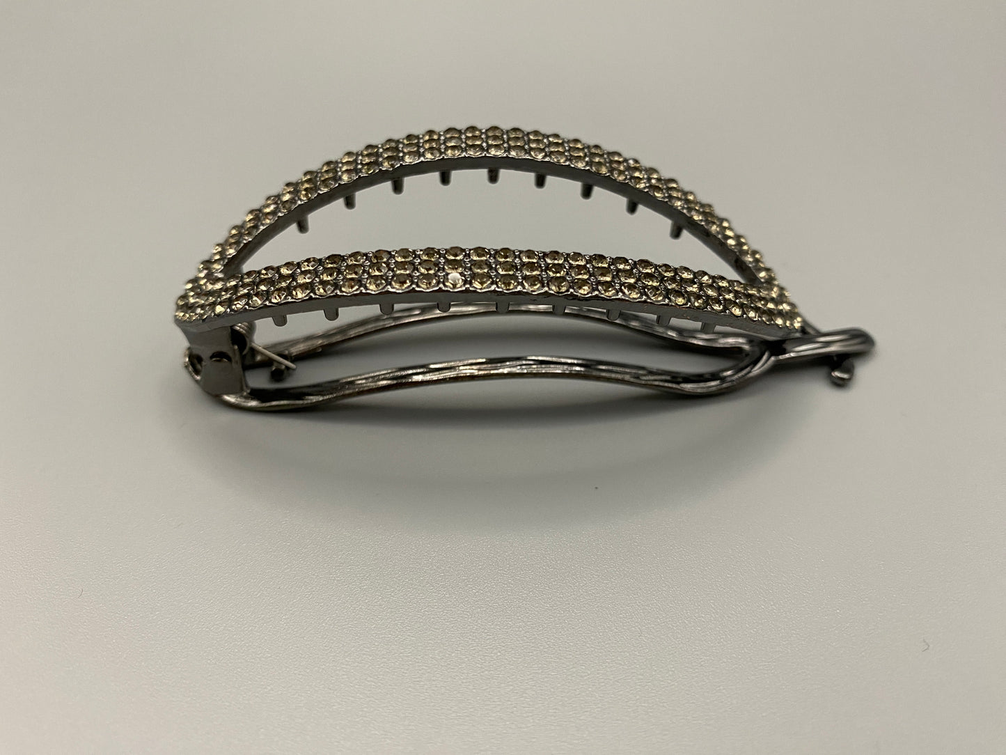 “The Missy Hair Clip, crafted from high-quality metal with sparkling zircon inlaid stones. Features a delicate curved design, measures 9 cm in length, and is perfect for securing various hair types and styles. Durable and luxurious, ideal for effortless beauty.”