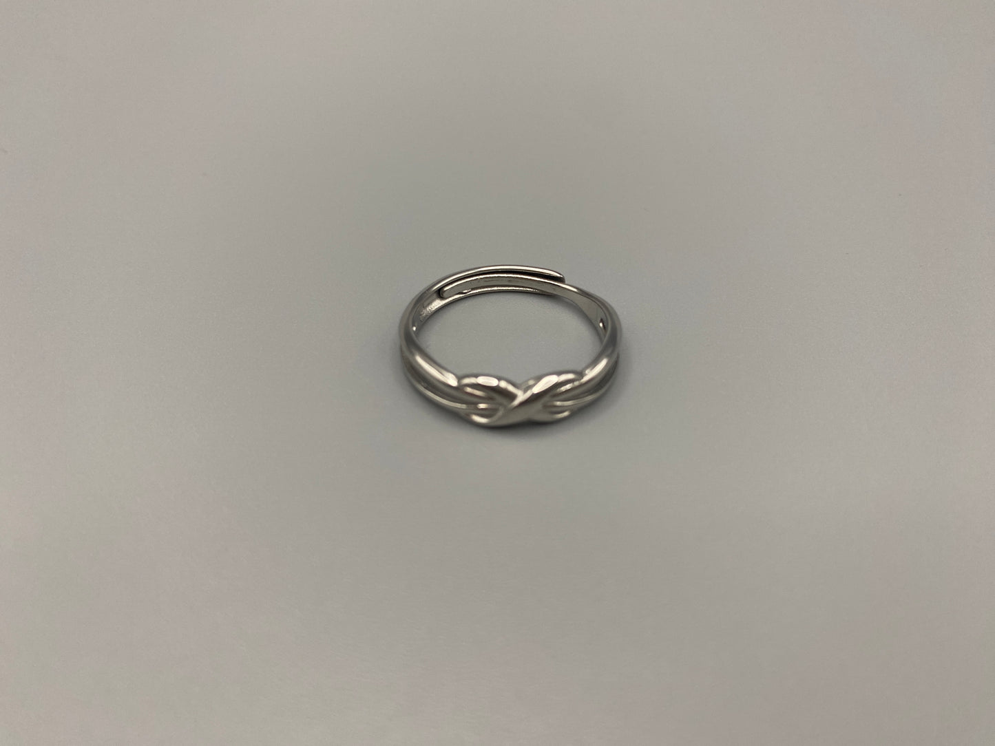 Tiana Silver Ring: Crafted from high-quality 316L stainless steel, this ring features a sleek, intertwined design that exudes sophistication. The adjustable, free-size band ensures a comfortable fit for any finger. Perfect for adding a trendy touch to any outfit.