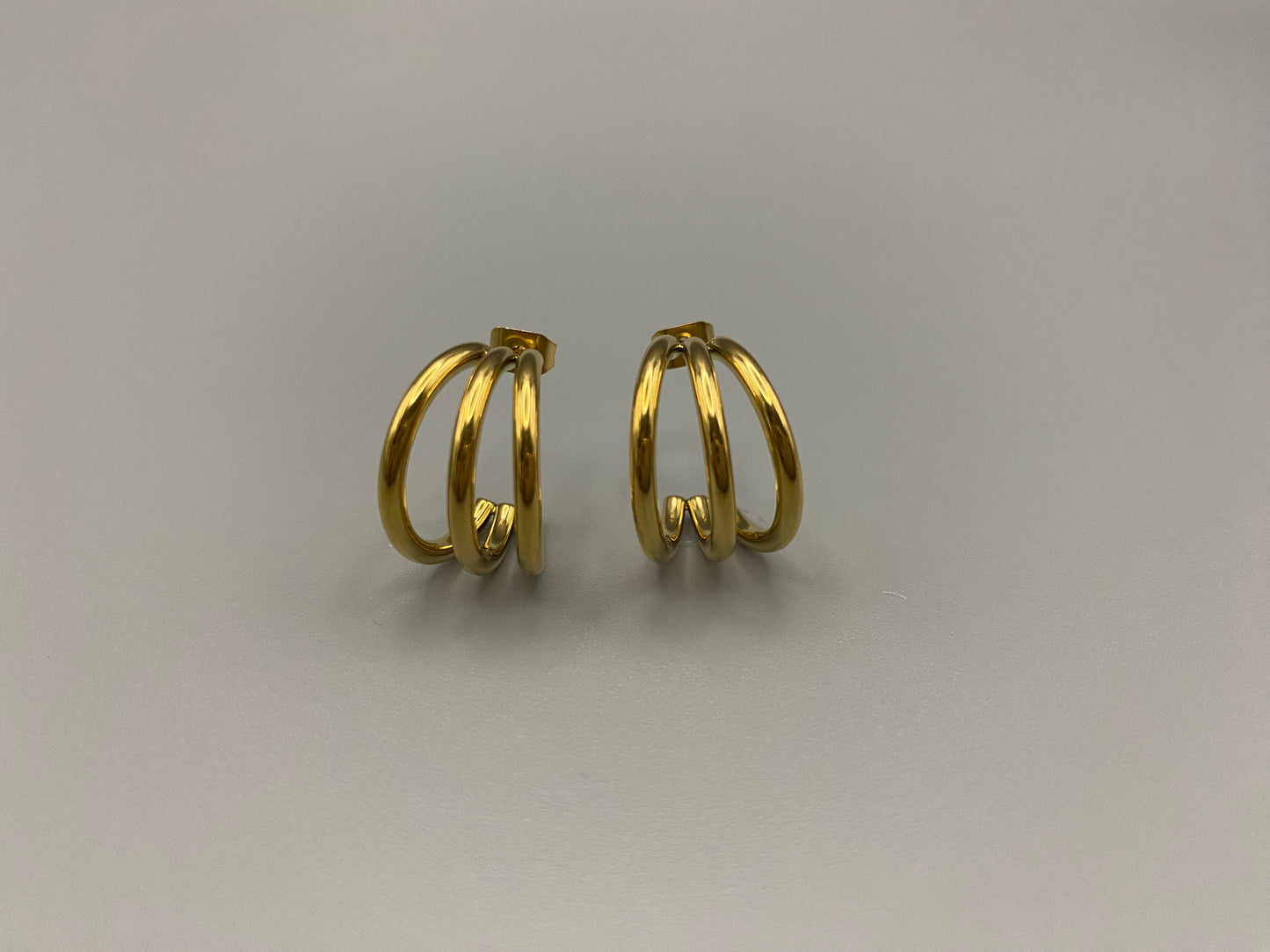 “Trinity 3 Band C Shaped Earrings Gold: A perfect blend of elegance and modern design, featuring a luxurious gold plating, unique three-band C shape, and durable construction. Ideal for both everyday wear and special occasions.”