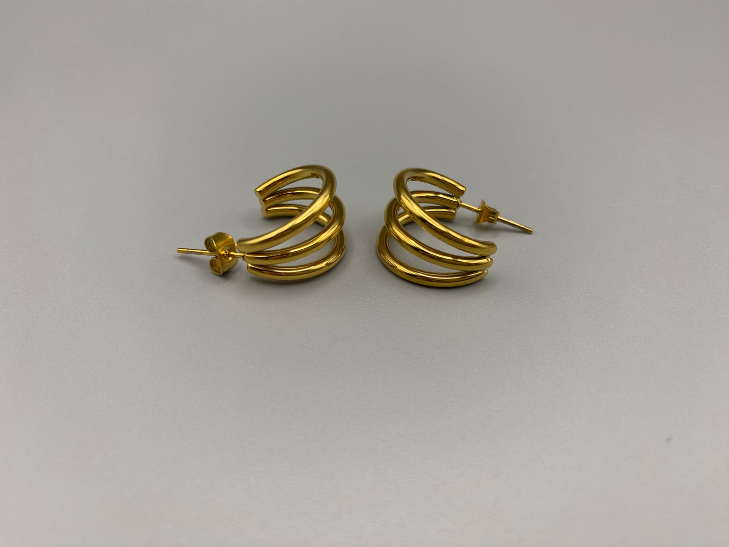 “Trinity 3 Band C Shaped Earrings Gold: A perfect blend of elegance and modern design, featuring a luxurious gold plating, unique three-band C shape, and durable construction. Ideal for both everyday wear and special occasions.”