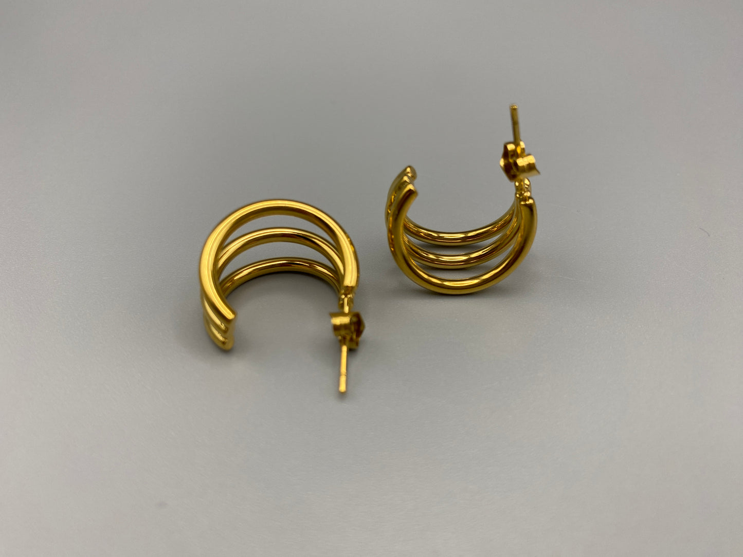 “Trinity 3 Band C Shaped Earrings Gold: A perfect blend of elegance and modern design, featuring a luxurious gold plating, unique three-band C shape, and durable construction. Ideal for both everyday wear and special occasions.”