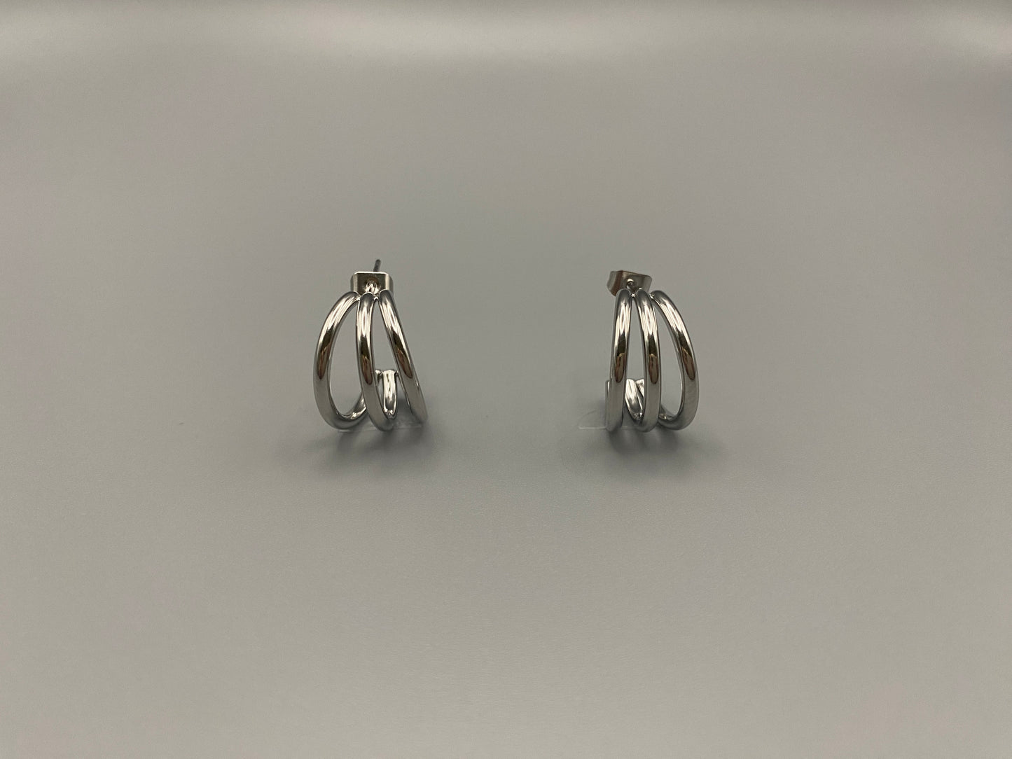 “Trinity 3 Band C Shaped Earrings Silver: A perfect blend of elegance and modern design, featuring sleek silver plating, a unique three-band C shape, and durable stainless steel construction. Ideal for both everyday wear and special occasions.”
