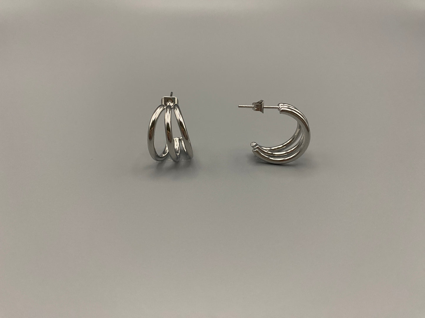 “Trinity 3 Band C Shaped Earrings Silver: A perfect blend of elegance and modern design, featuring sleek silver plating, a unique three-band C shape, and durable stainless steel construction. Ideal for both everyday wear and special occasions.”