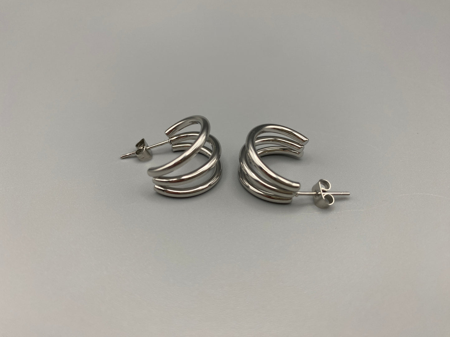 “Trinity 3 Band C Shaped Earrings Silver: A perfect blend of elegance and modern design, featuring sleek silver plating, a unique three-band C shape, and durable stainless steel construction. Ideal for both everyday wear and special occasions.”