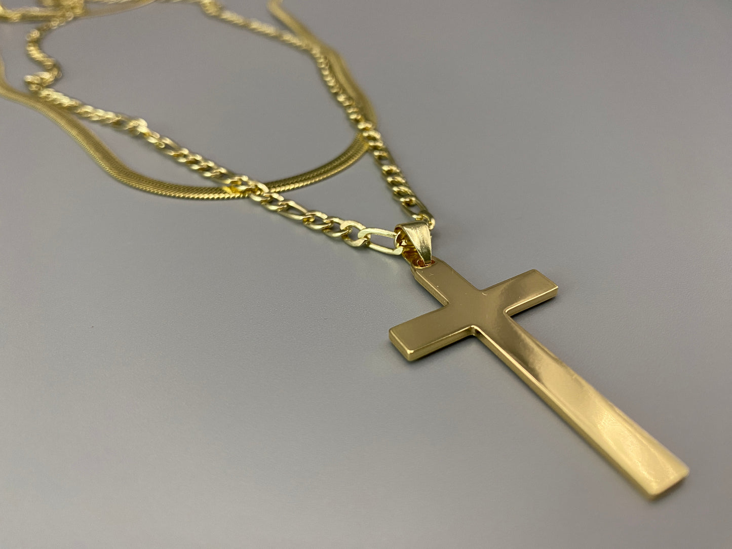 “Men’s Twin Chain Cross Necklace: A stylish 18k gold plated stainless steel necklace featuring a twin chain design with a gold cross pendant. Perfect for teens and adults, this fine jewelry piece is unisex and measures 45 cm with a 5 cm extender.”