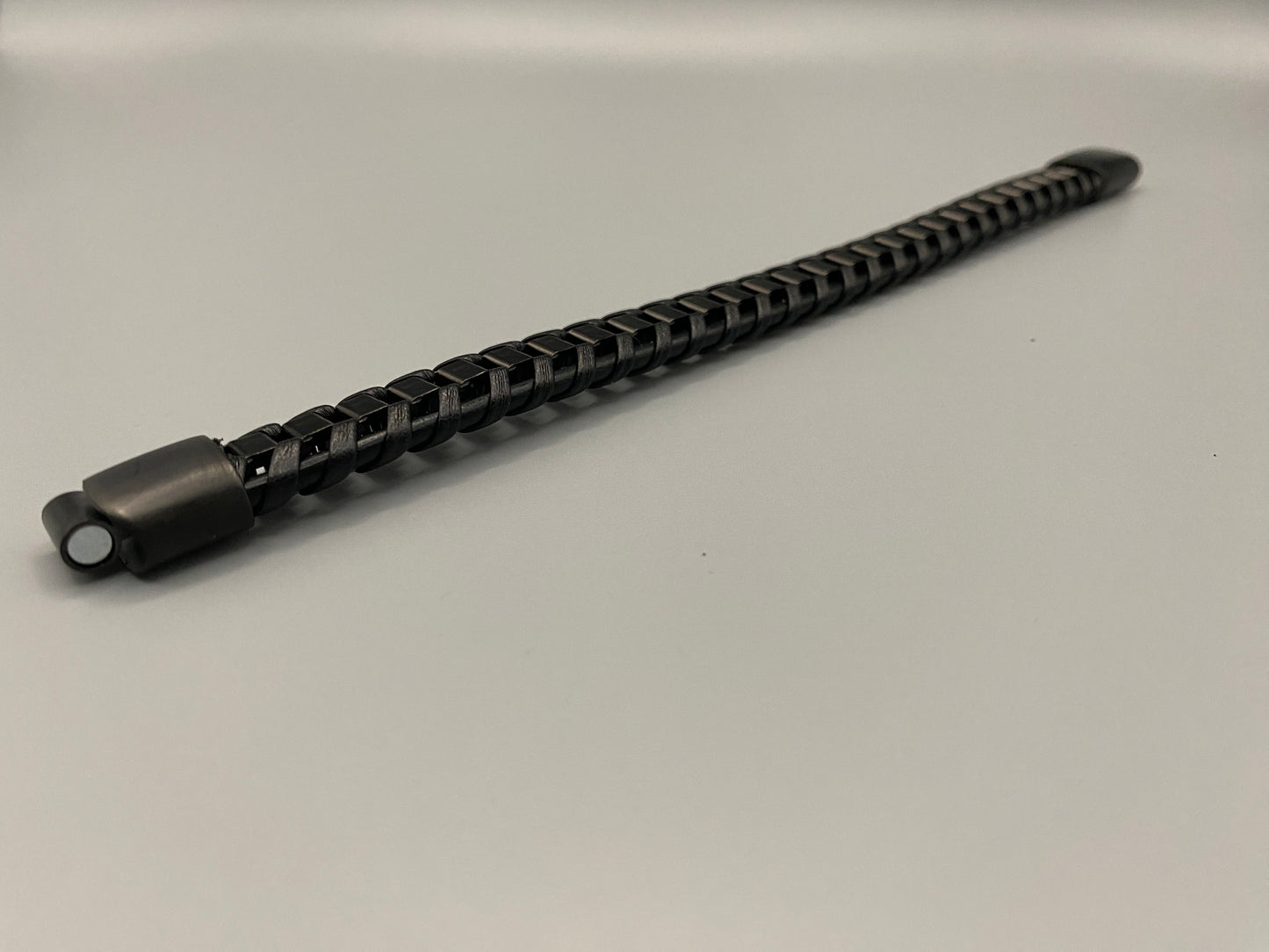 “Urban Edge Wrist Wear Men’s Bracelet in black, crafted from premium stainless steel with a casual and sporty design. Measures 19 cm in length, available in Black Zinc Plated, 18K Gold Plated, and Silver Plated finishes. Features inlay technology for added detail and craftsmanship.”