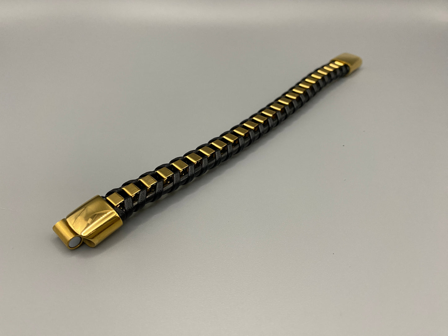 “Urban Edge Wrist Wear Men’s Bracelet in black, crafted from premium stainless steel with a casual and sporty design. Measures 19 cm in length, available in Black Zinc Plated, 18K Gold Plated, and Silver Plated finishes. Features inlay technology for added detail and craftsmanship.”