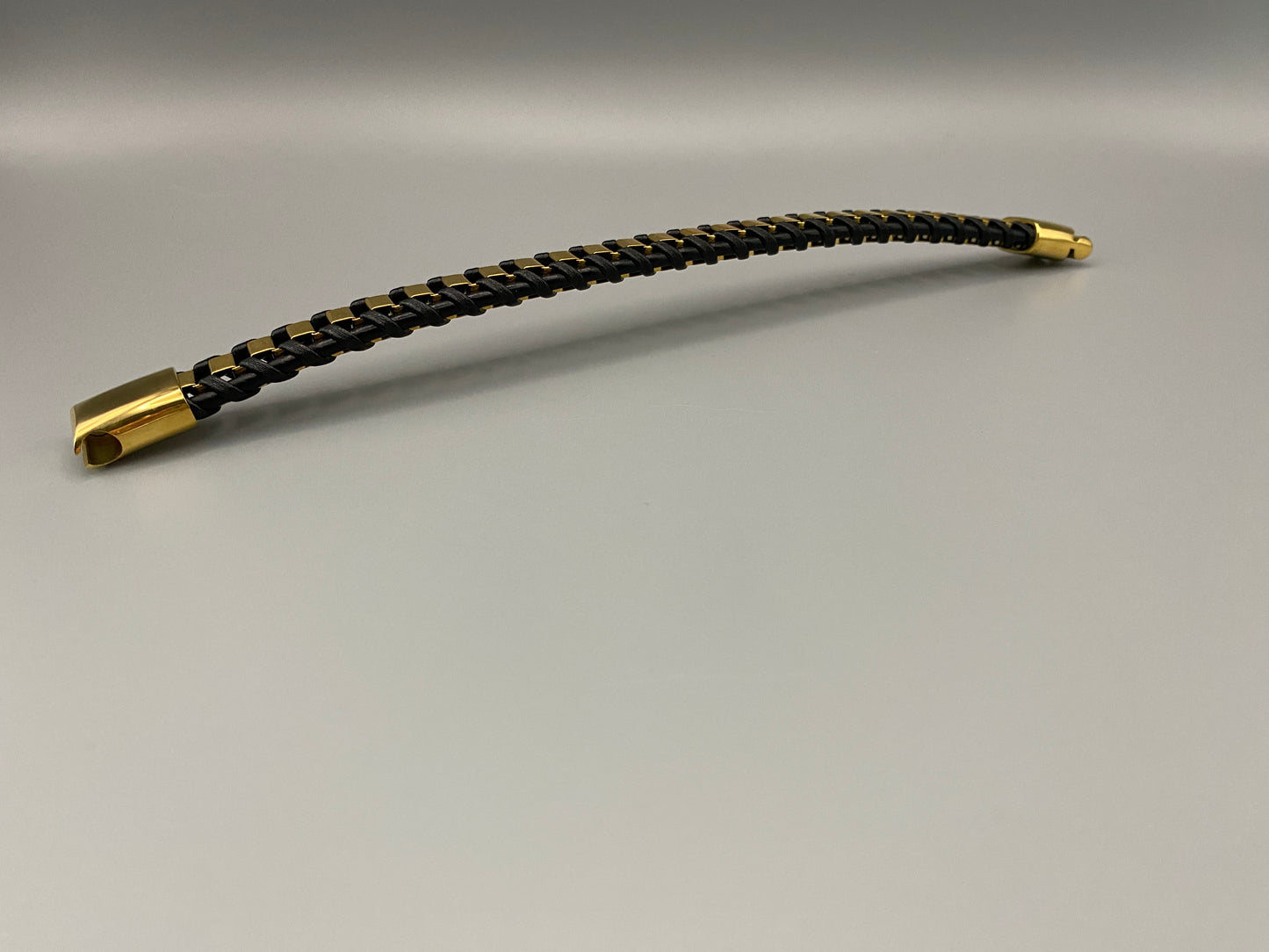 “Urban Edge Wrist Wear Men’s Bracelet in black, crafted from premium stainless steel with a casual and sporty design. Measures 19 cm in length, available in Black Zinc Plated, 18K Gold Plated, and Silver Plated finishes. Features inlay technology for added detail and craftsmanship.”