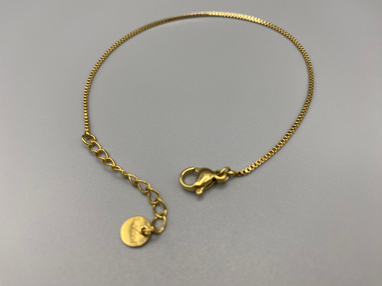 “Venice Fine Box Chain Bracelet in Gold. Made from 316L stainless steel, this 18+3cm adjustable bracelet is gold plated, eco-friendly (nickel and lead-free), and waterproof. Stylish and practical, it adds a touch of elegance to any jewellery collection.”