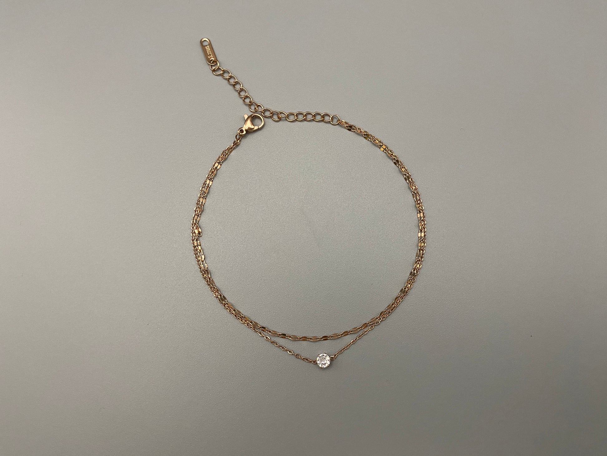 Aurora Twin Chain Bracelet in rose gold with a sophisticated twin chain design, adorned with zirconia gemstones. Waterproof and measures 18 cm with a 3 cm extender for adjustable fit.”