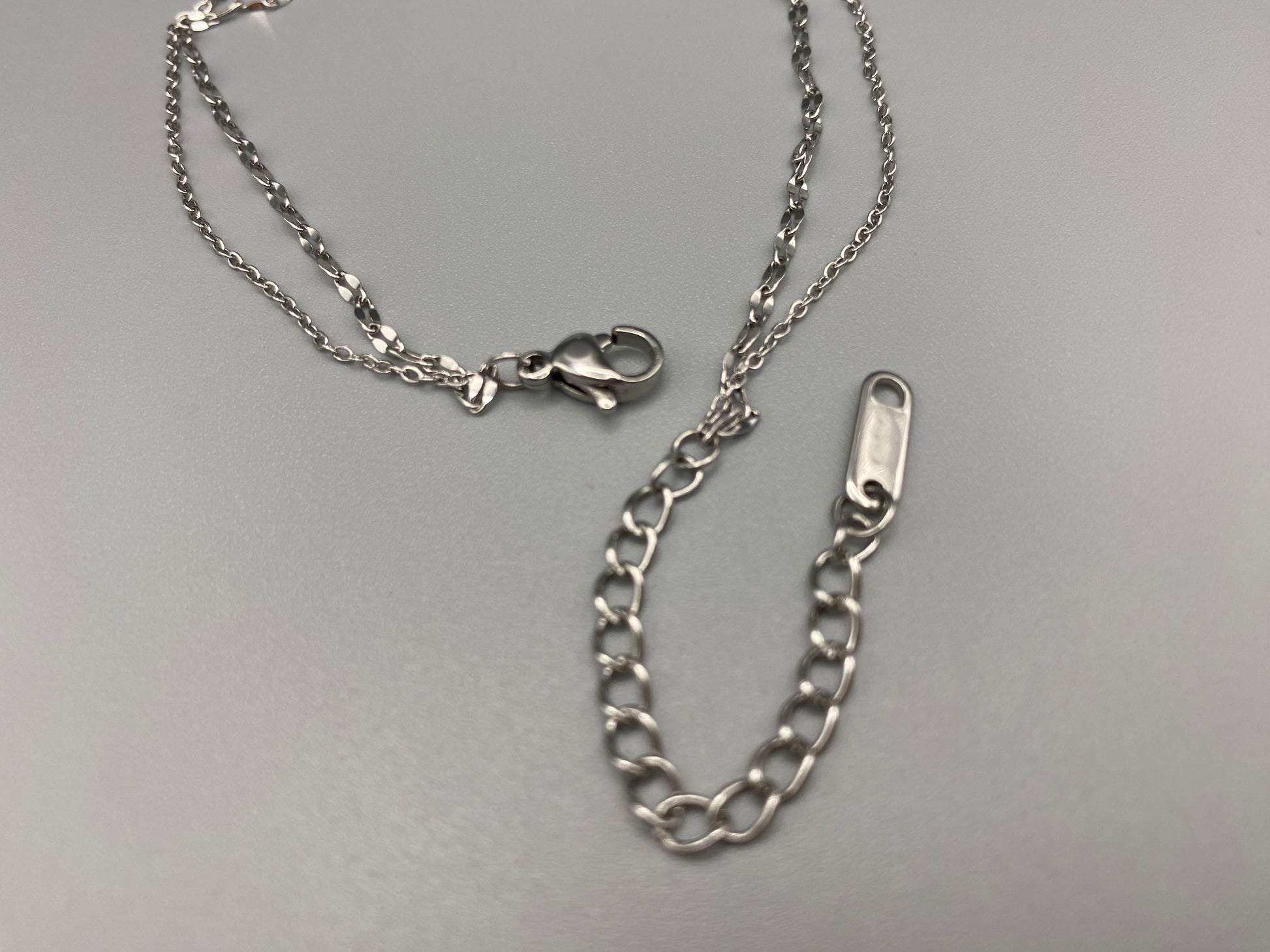 Aurora Twin Chain Bracelet in silver with a sophisticated twin chain design, adorned with sparkling zirconia gemstones. Waterproof and measures 18 cm with a 3 cm extender for adjustable fit.”
