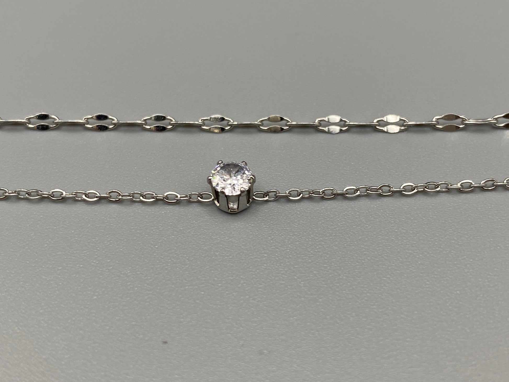 Aurora Twin Chain Bracelet in silver with a sophisticated twin chain design, adorned with sparkling zirconia gemstones. Waterproof and measures 18 cm with a 3 cm extender for adjustable fit.”