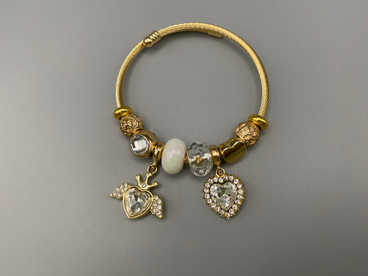 “Belle White Charm Bracelet with gold-plated finish, featuring heart-cut crystals and rhinestones. Made from durable stainless steel with playful charms and micro insert inlay technology.”