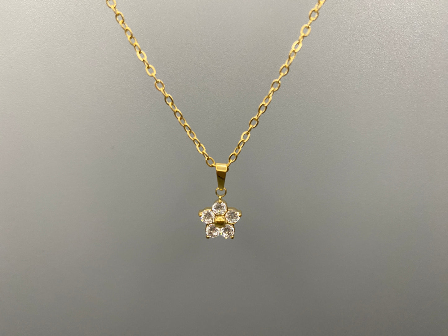 “Blossom Gold Pendant Necklace with a plum blossom design, featuring a colourful clear cubic zirconia stones in a claw setting. Made from durable stainless steel with PVD gold plating. Measures 46 cm with a 5 cm adjustment.”