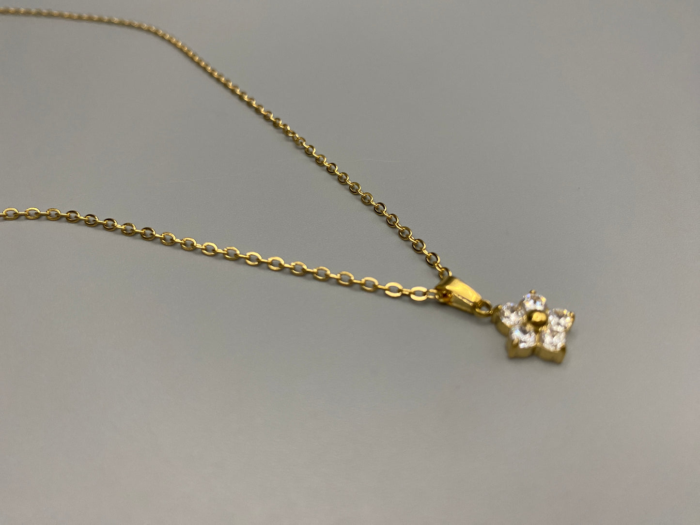 “Blossom Gold Pendant Necklace with a plum blossom design, featuring a colourful clear cubic zirconia stones in a claw setting. Made from durable stainless steel with PVD gold plating. Measures 46 cm with a 5 cm adjustment.”