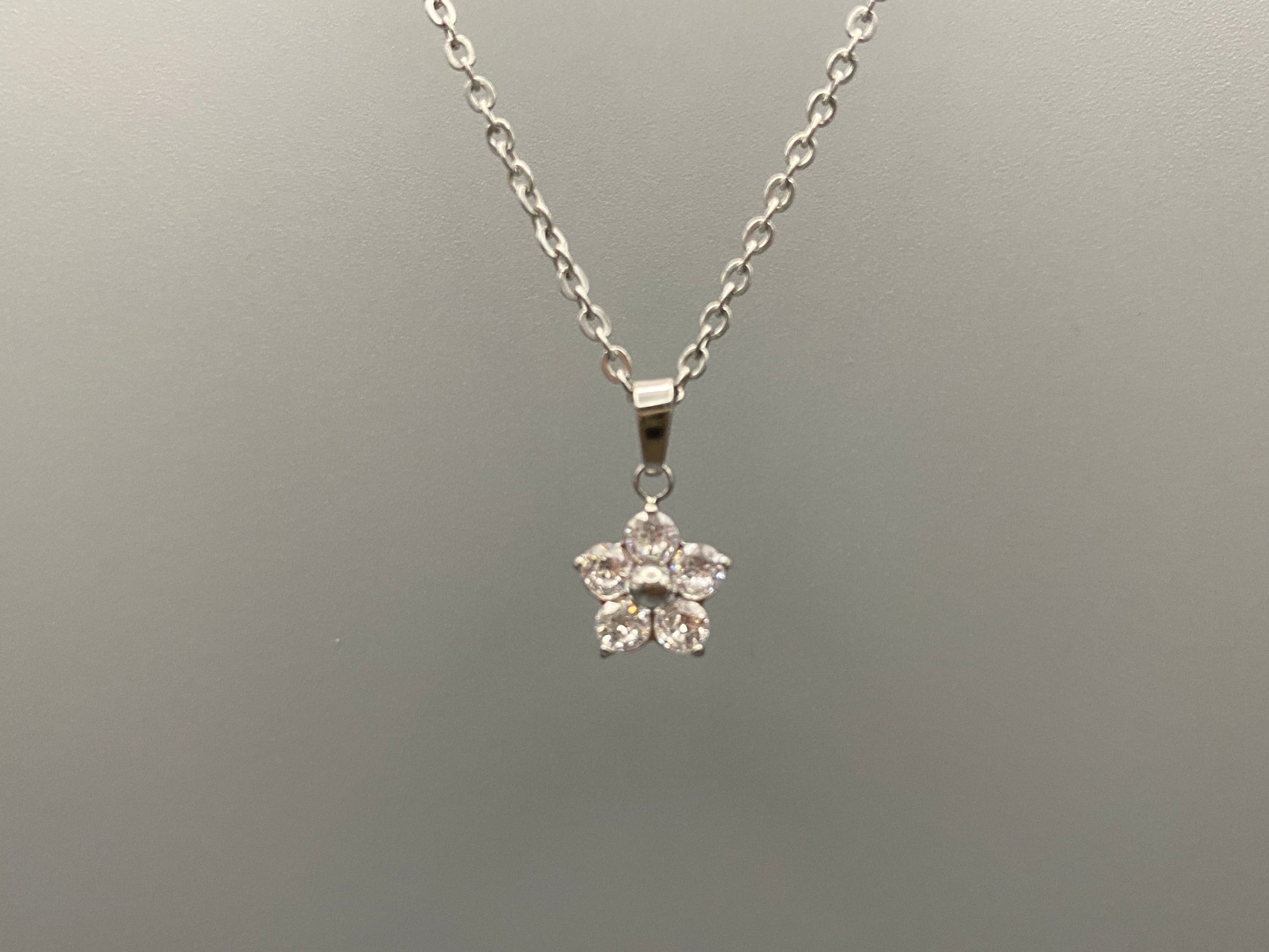 “Blossom Silver Pendant Necklace with a plum blossom design, featuring colourful cubic zirconia stones in a claw setting. Made from durable stainless steel with PVD plating. Measures 46 cm with a 5 cm adjustment.”