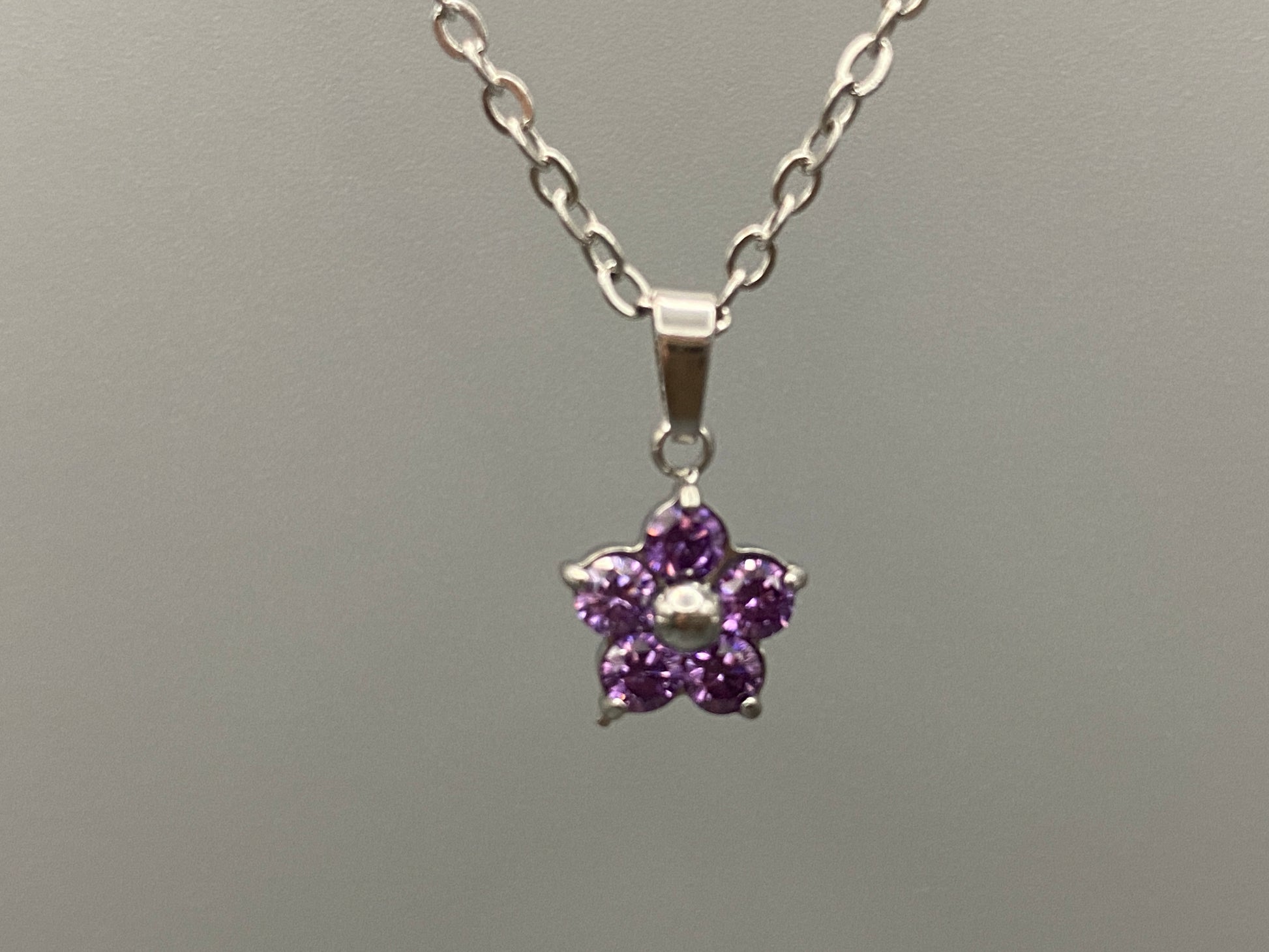 “Blossom Silver Pendant Necklace with a plum blossom design, featuring colourful cubic zirconia stones in a claw setting. Made from durable stainless steel with PVD plating. Measures 46 cm with a 5 cm adjustment.”