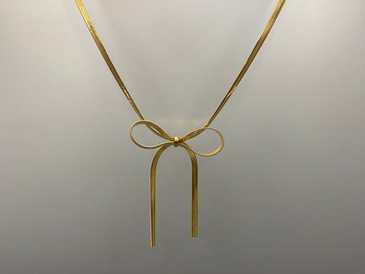 “Celest Angel Bow Pendant Chain in gold with a sophisticated bow pendant design. Made from durable stainless steel, tarnish-free. Measures 35 cm with a 5 cm extender for adjustable fit.”