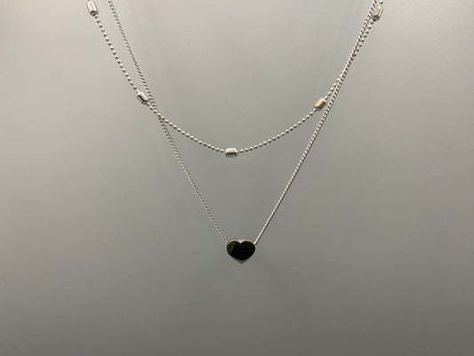 Cora Twin Chain Heart and Bead Necklace in Silver. Features: Durable Material: Crafted from stainless steel, known for its strength and resistance to tarnish. Elegant Design: The twin chain design with beads and heart elements adds a touch of sophistication. Adjustable Length: Measures 41 cm with an additional 5 cm extension for a customizable and comfortable fit. PVD Plating: Provides enhanced durability and resistance to wear, ensuring lasting beauty.