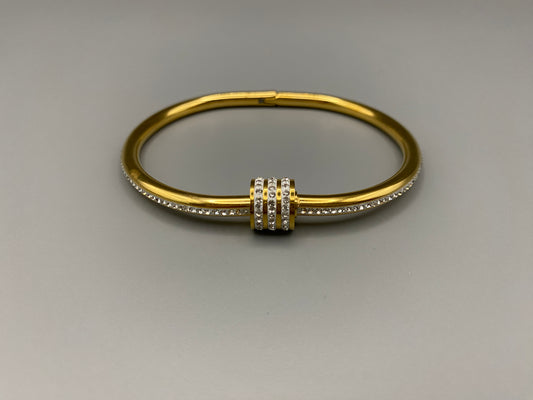 “Eclipse Encrusted Bangle Bracelet in gold with an encrusted gem inlay, featuring 18K gold plating and a thread open and close mechanism for easy adjustment. Made from high-quality materials for long-lasting wear.”