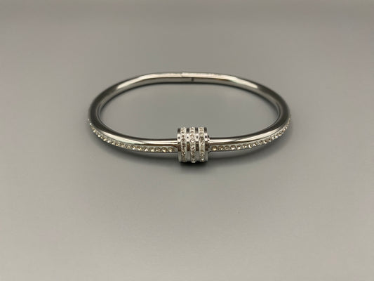 “Eclipse Encrusted Bangle Bracelet in silver with an encrusted gem inlay, featuring silver plating and a thread open and close mechanism for easy adjustment. Made from high-quality materials for long-lasting wear.”