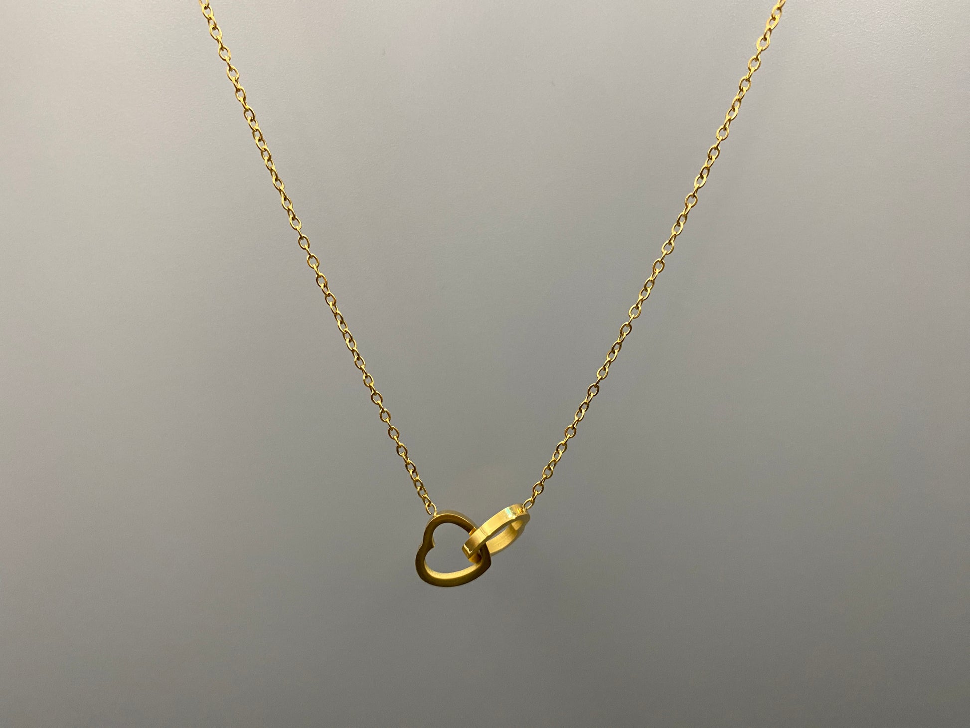 Eternity Twin Hearts Pendant Necklace Gold. Two intertwined hearts symbolizing eternal love. 18k gold, non-tarnish, waterproof, non-fade. Adjustable length: 41 cm + 5 cm extender. Elegant and versatile for any occasion.