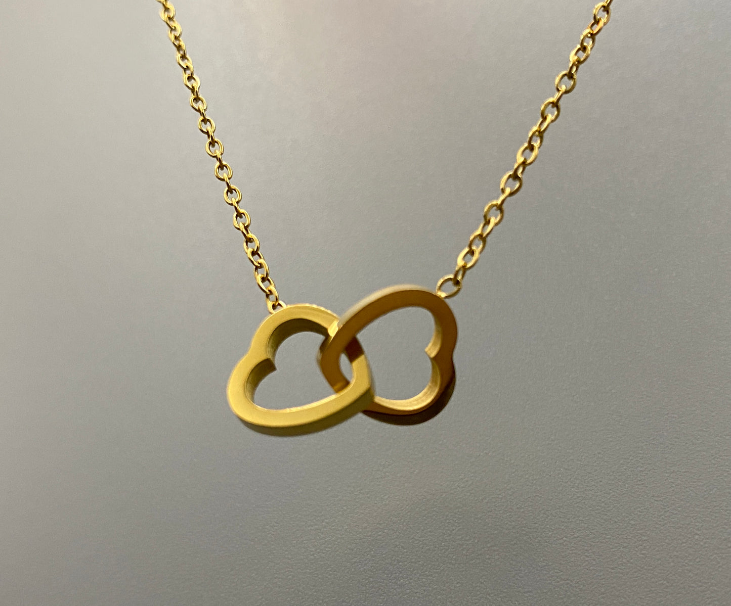 Eternity Twin Hearts Pendant Necklace Gold. Two intertwined hearts symbolizing eternal love. 18k gold, non-tarnish, waterproof, non-fade. Adjustable length: 41 cm + 5 cm extender. Elegant and versatile for any occasion.