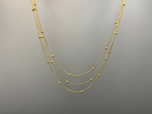 Freya Tri-Chain Bead Necklace Gold. Elegant tri-chain design with bead accents. 18k gold plated, PVD plated for durability. Adjustable length: 40 cm + 5 cm extender. Versatile for layering or solo wear.