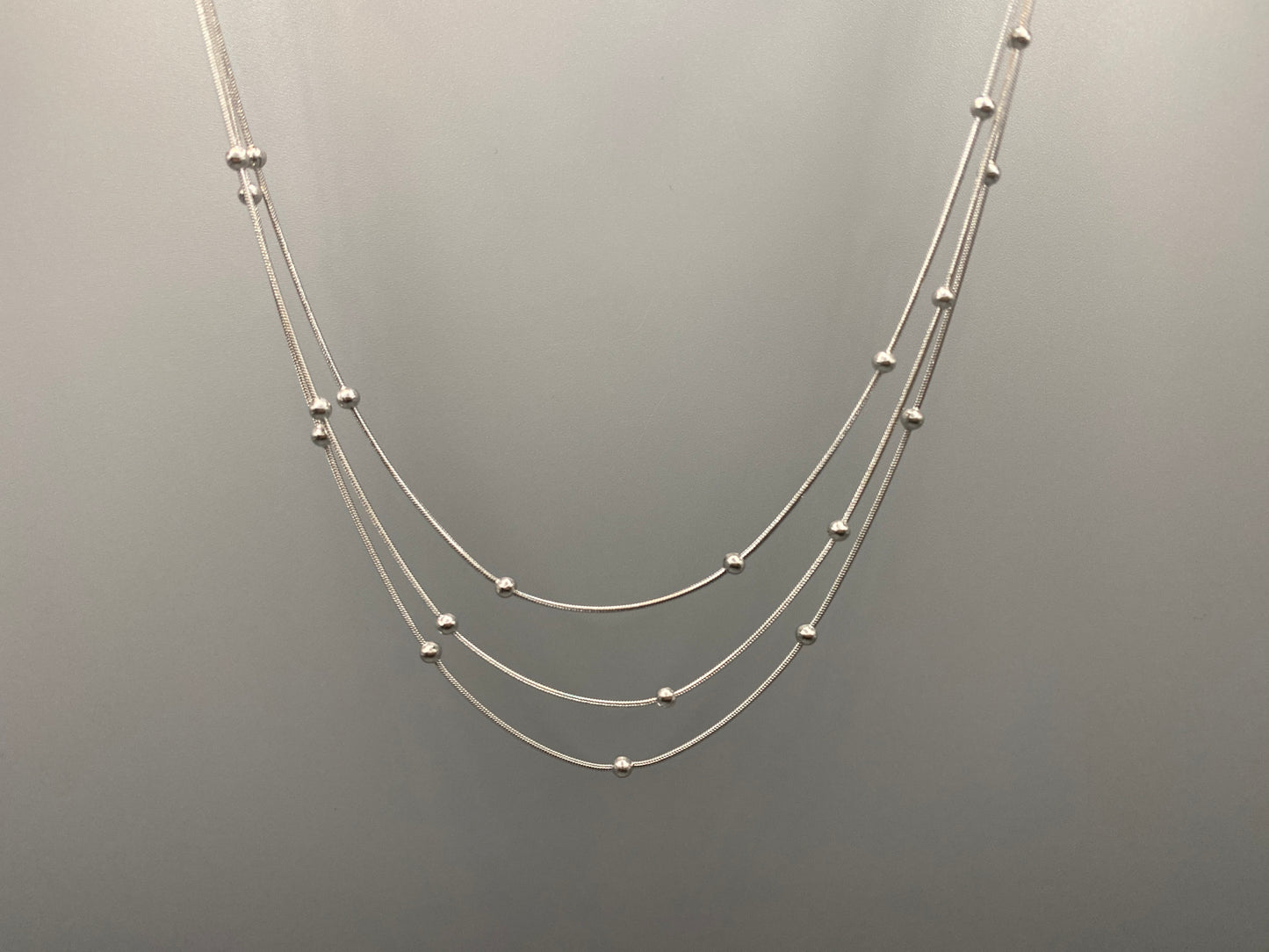 Elegant tri-chain design with bead accents. silver plated, PVD plated for durability. Adjustable length: 40 cm + 5 cm extender. Versatile for layering or solo wear.