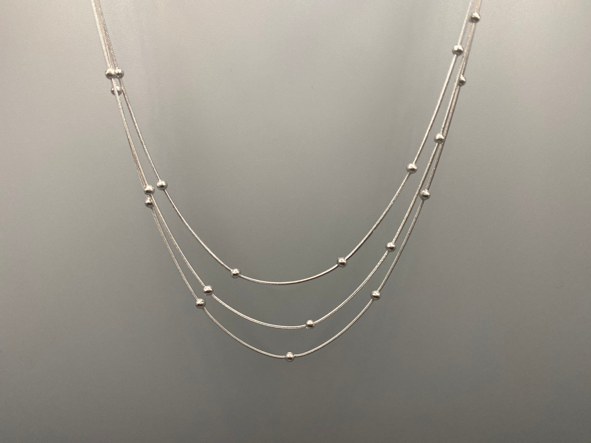 Elegant tri-chain design with bead accents. silver plated, PVD plated for durability. Adjustable length: 40 cm + 5 cm extender. Versatile for layering or solo wear.