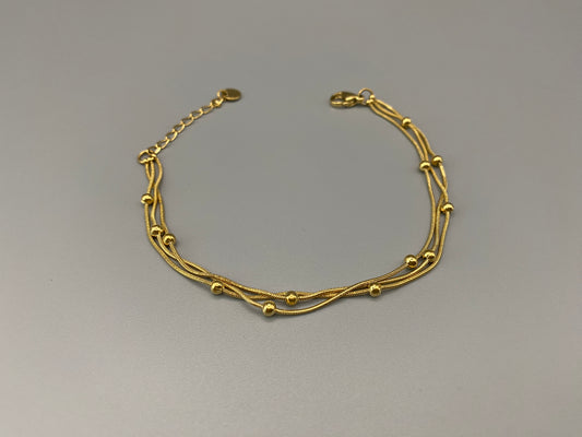 Freya Tri-Chained Bead Bracelet in gold with three delicate chains and evenly spaced small beads. 18K gold plated, made from durable stainless steel with PVD plating. Measures 18 cm with a 3 cm extender for adjustable fit.”