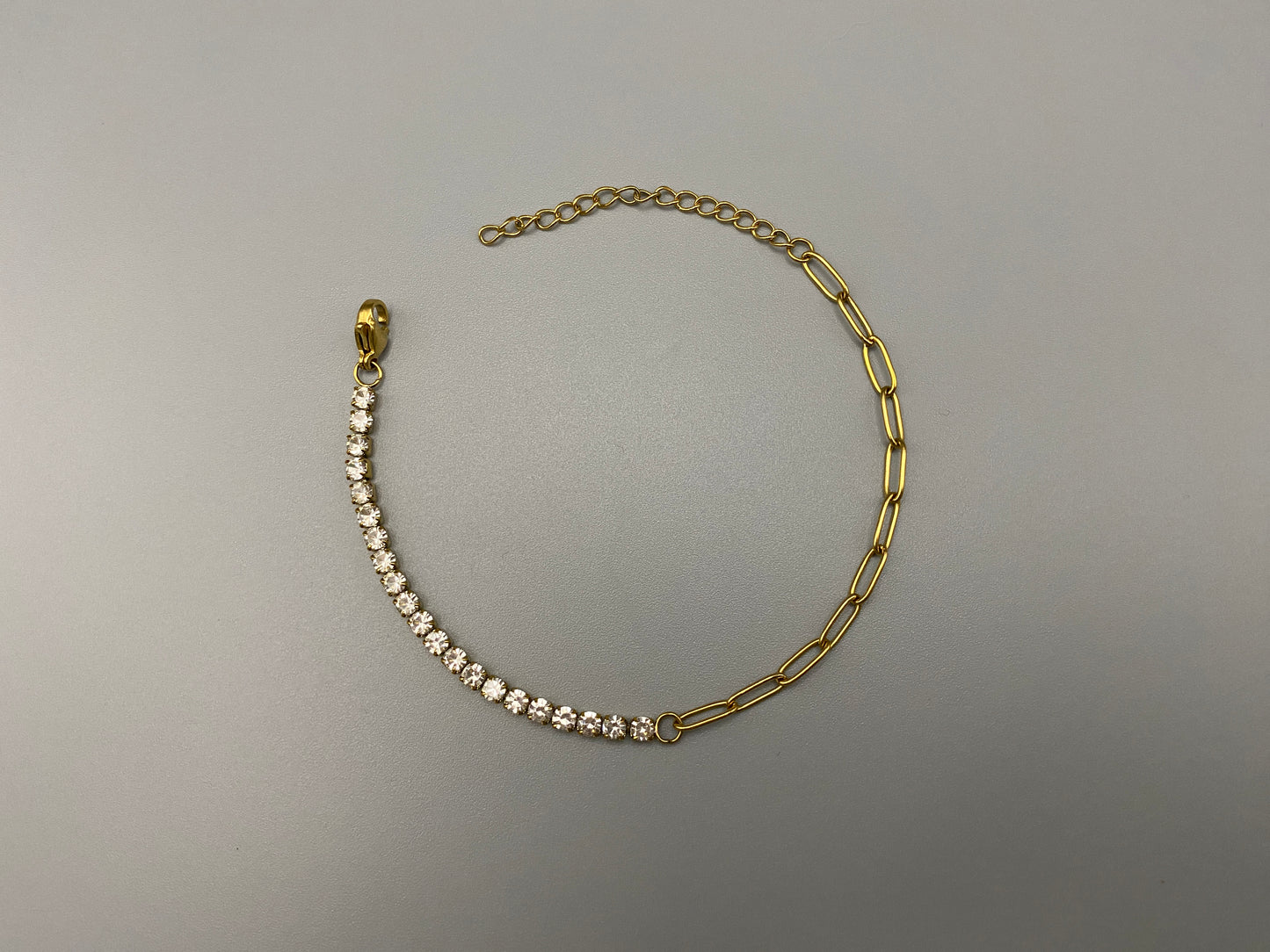 “Gemma Bracelet in gold with iced-out zircon paperclip chain, crafted from tarnish-free stainless steel and plated with 18K gold. Waterproof and perfect for daily wear or special occasions.”