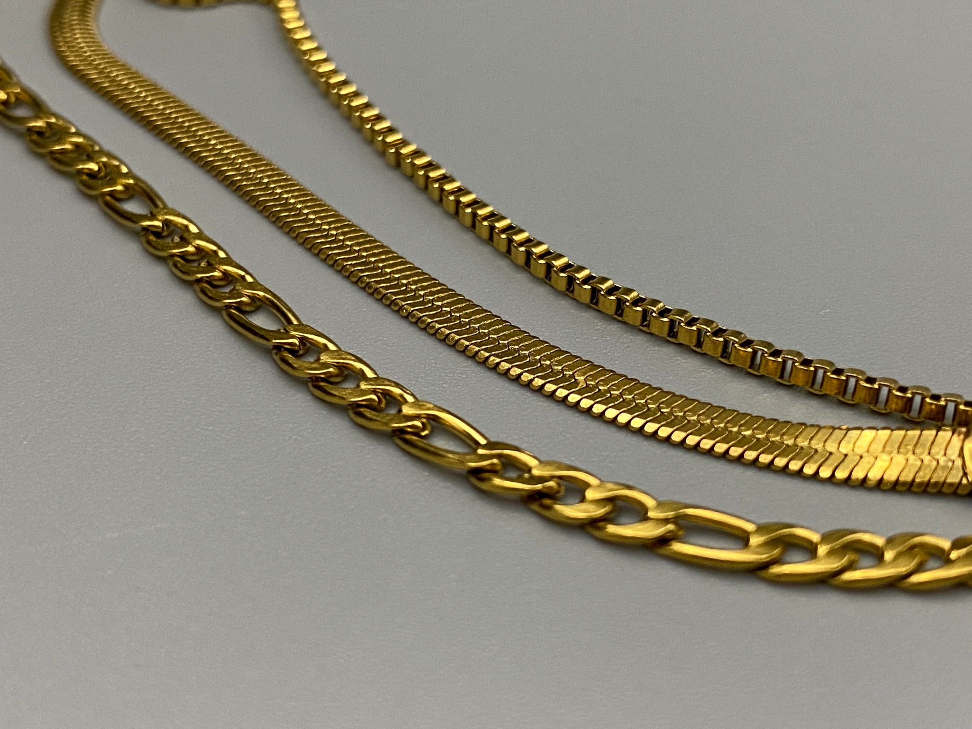 Gina Three Layered Gold Chain Necklace. Three delicate chains layered for a sophisticated look. 18k gold plated, PVD plated for durability. Stainless steel, corrosion-resistant. Adjustable length: 40 cm + 5 cm extender. Versatile for casual and formal wear.