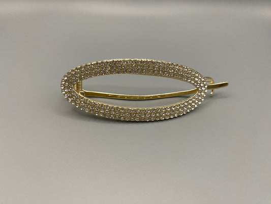 GlitzGrip Hollow Gold Hair Clip featuring a hollow oval design with “sparkling zircon gems, measuring 9.5 cm in length. Elegant and durable, perfect for various hairstyles.”
