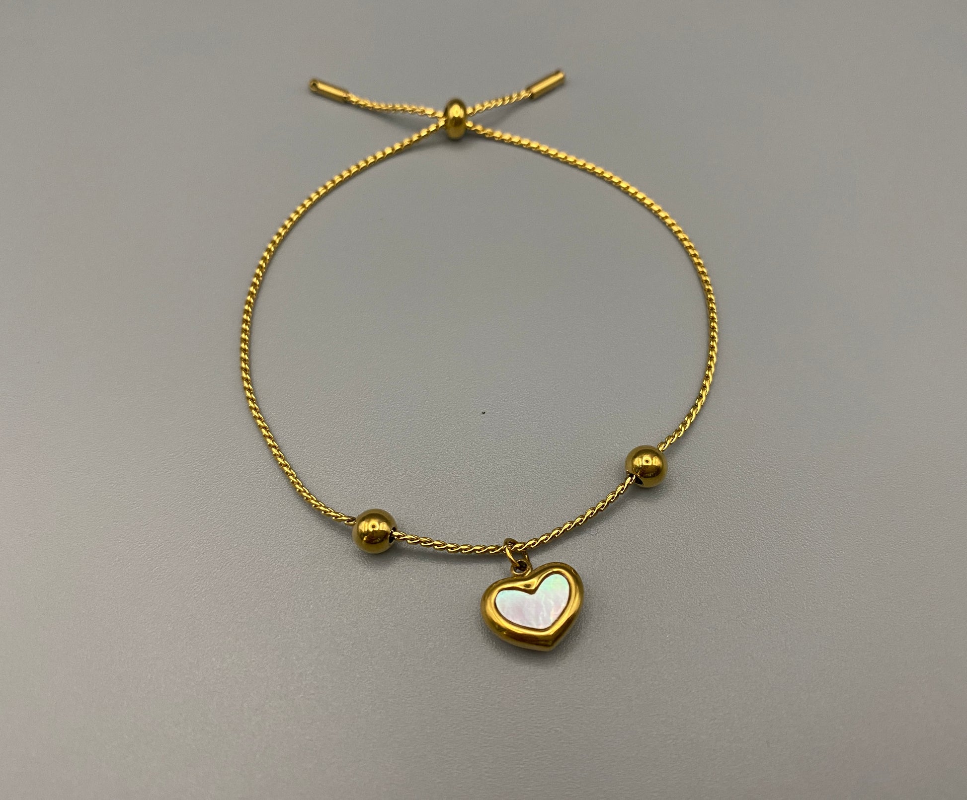 “Helena Heart Bracelet in gold with a white shell heart pendant, crafted from high-quality stainless steel and plated with 18K gold. Adjustable, waterproof, tarnish-free, and environmentally friendly.”