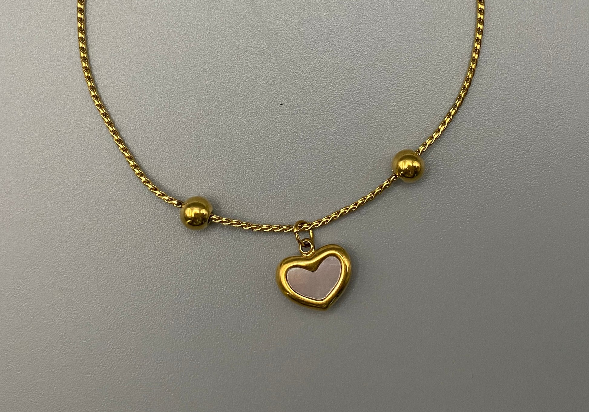 “Helena Heart Bracelet in gold with a white shell heart pendant, crafted from high-quality stainless steel and plated with 18K gold. Adjustable, waterproof, tarnish-free, and environmentally friendly.”