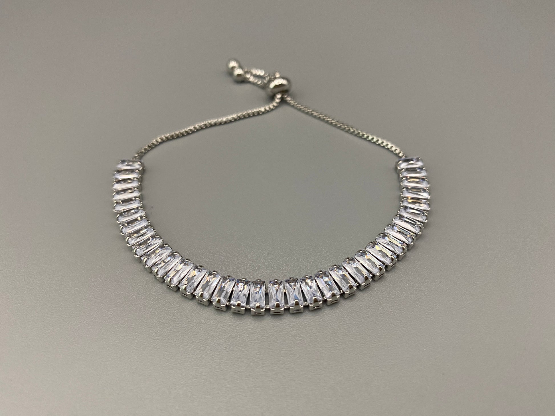 “Isdis Bracelet with a luxurious hip hop design, made from high-quality copper and adorned with sparkling zirconia stones. Features an adjustable closure with pull strings.”