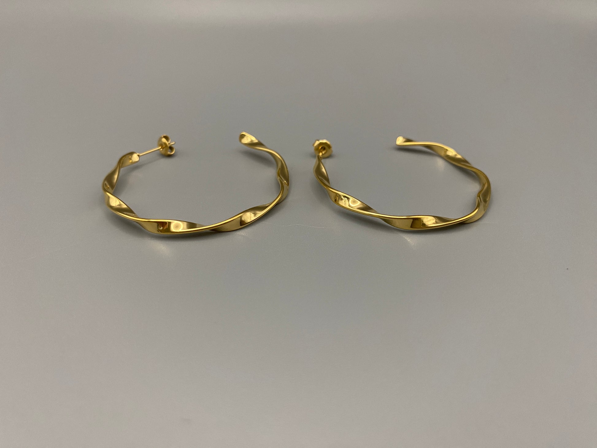“Leanne C Shape Earrings Gold: Fashion-forward twisted wire earrings with an irregular C-shaped design, crafted from high-quality stainless steel and plated with luxurious 18K gold. Perfect for any occasion.”