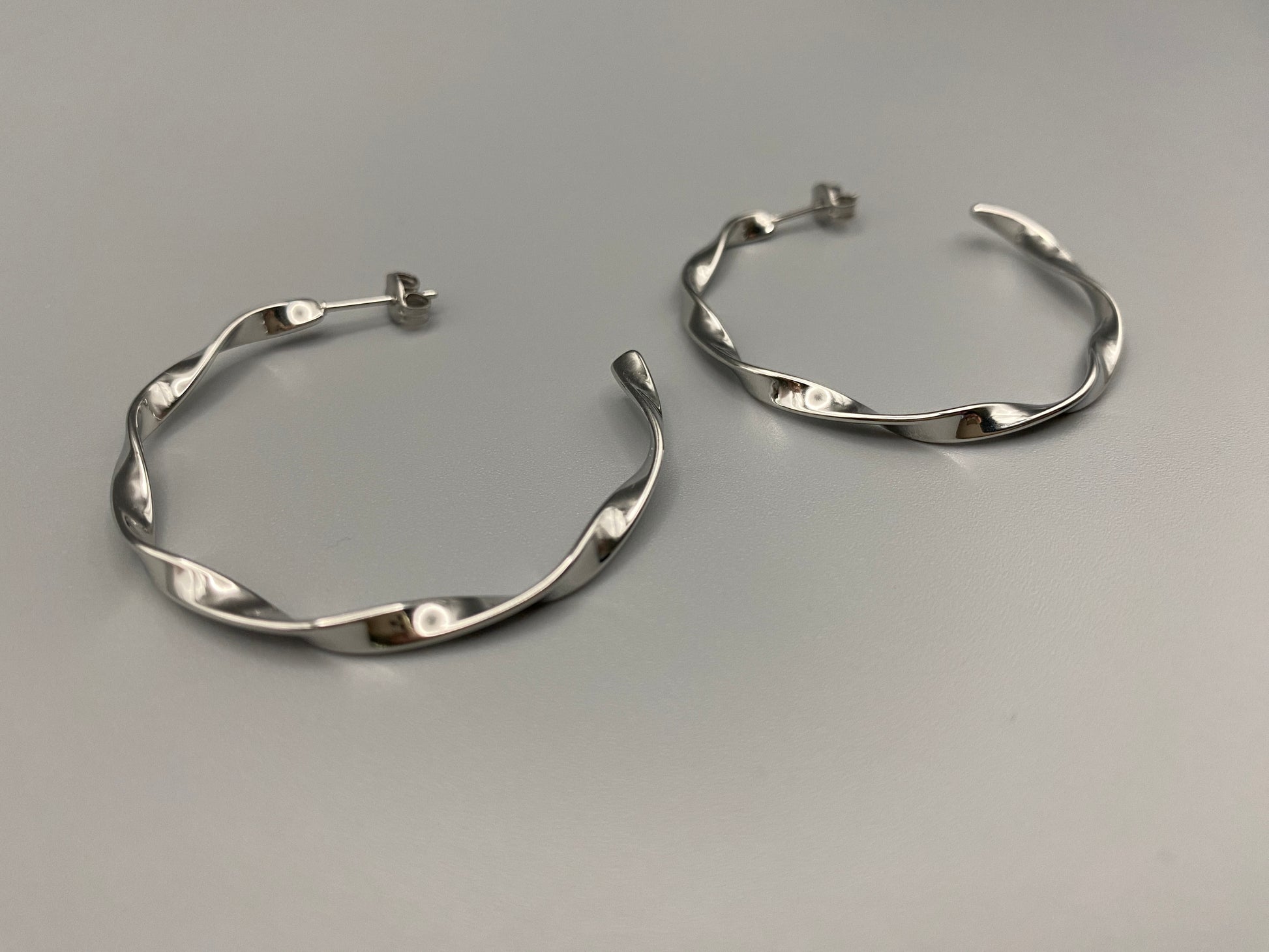 “Leanne C Shape Earrings Silver: Fashion-forward twisted wire earrings with an irregular C-shaped design, crafted from high-quality stainless steel and plated with luxurious silver. Perfect for any occasion.”