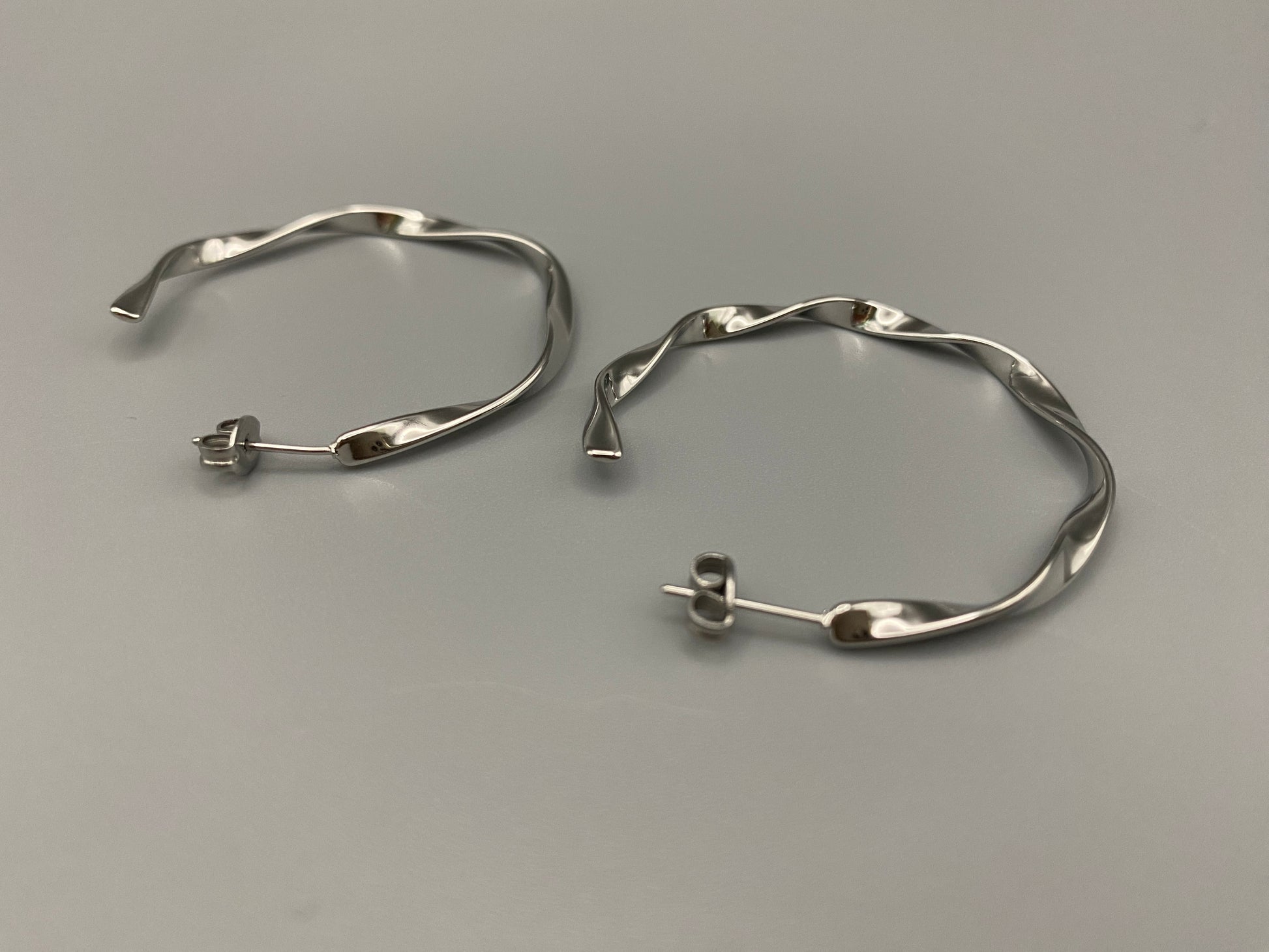 “Leanne C Shape Earrings Silver: Fashion-forward twisted wire earrings with an irregular C-shaped design, crafted from high-quality stainless steel and plated with luxurious silver. Perfect for any occasion.”