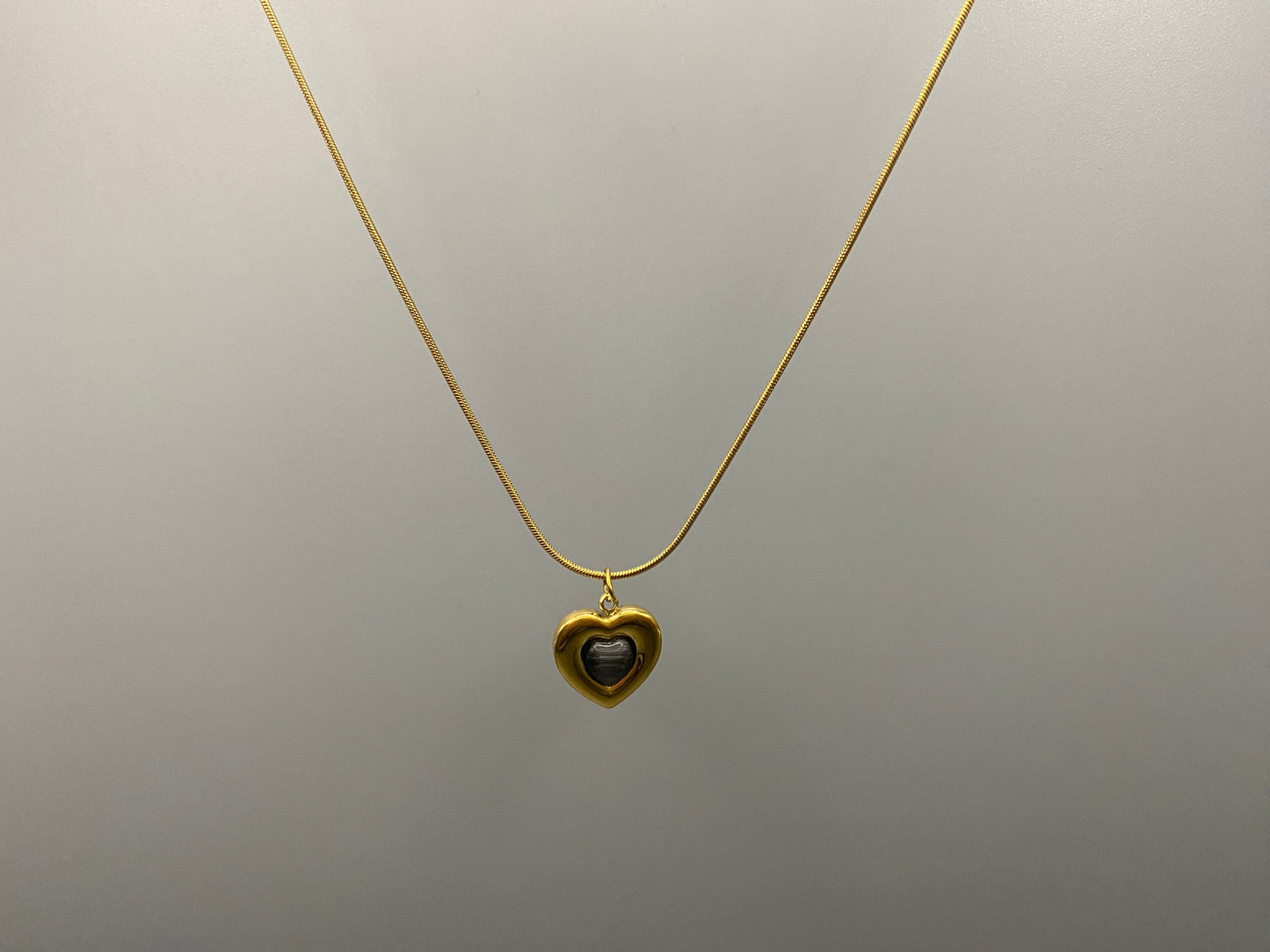 Lucia Heart Gold Necklace. Heart-shaped pendant with obsidian stone. High-quality stainless steel, 18k gold plated. Measures 40 cm + 5 cm adjustment. Trendy, fashionable, environmentally friendly. Suitable for anniversaries, gifts, parties, and daily wear.