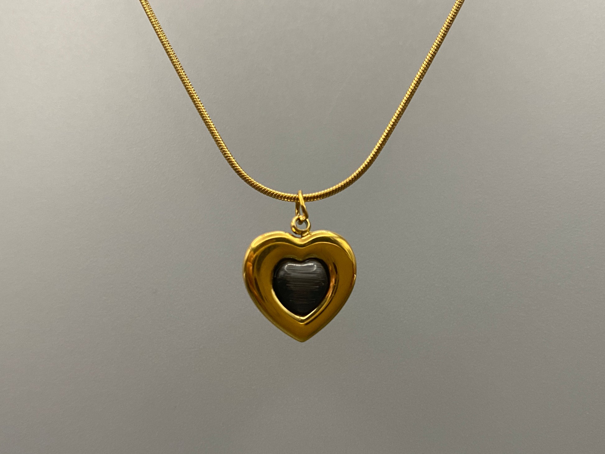 Lucia Heart Gold Necklace. Heart-shaped pendant with obsidian stone. High-quality stainless steel, 18k gold plated. Measures 40 cm + 5 cm adjustment. Trendy, fashionable, environmentally friendly. Suitable for anniversaries, gifts, parties, and daily wear.