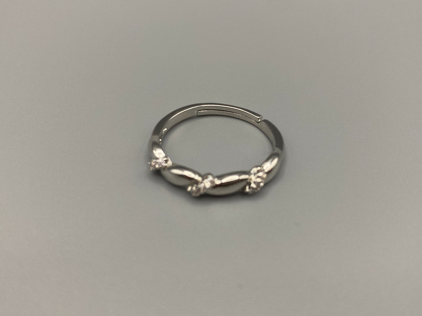 Olivia Adjustable Ring Silver: This exquisite piece plated, offering a luxurious shine and timeless appeal. The ring is waterproof and non-tarnish, ensuring it maintains its beauty over time. Cubic zirconia accents add sparkle and elegance, while the adjustable design ensures a perfect fit for any finger size. Make a statement with this stunning piece that complements any look.