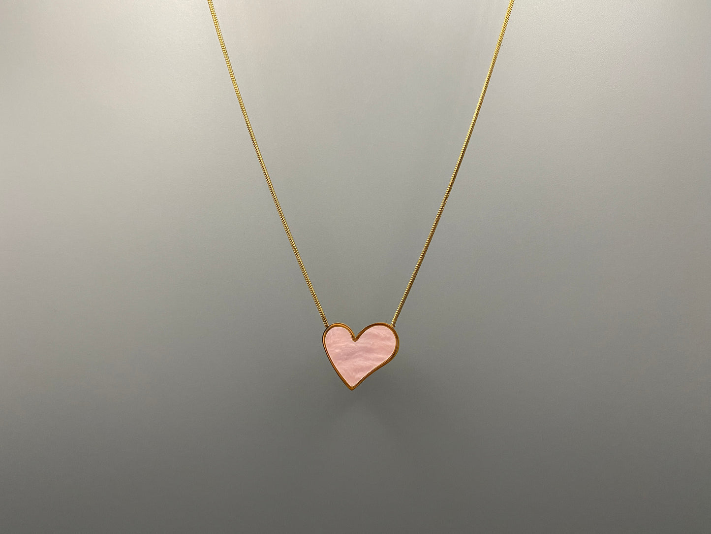 Paris Pink Heart Necklace. Big love heart pendant on a sleek snake chain. High-quality stainless steel, gold-plated. Measures 46 cm + 5 cm adjustment. Elegant princess cut heart pendant. Versatile for daily wear or special occasions.