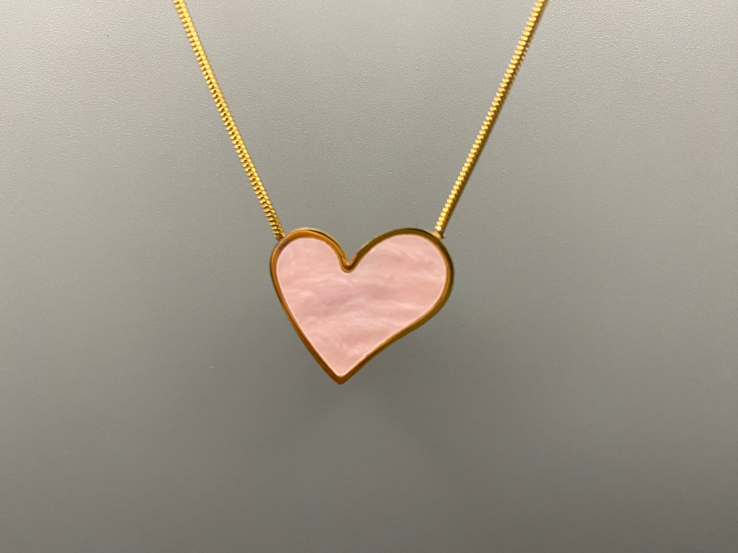 Paris Pink Heart Necklace. Big love heart pendant on a sleek snake chain. High-quality stainless steel, gold-plated. Measures 46 cm + 5 cm adjustment. Elegant princess cut heart pendant. Versatile for daily wear or special occasions.