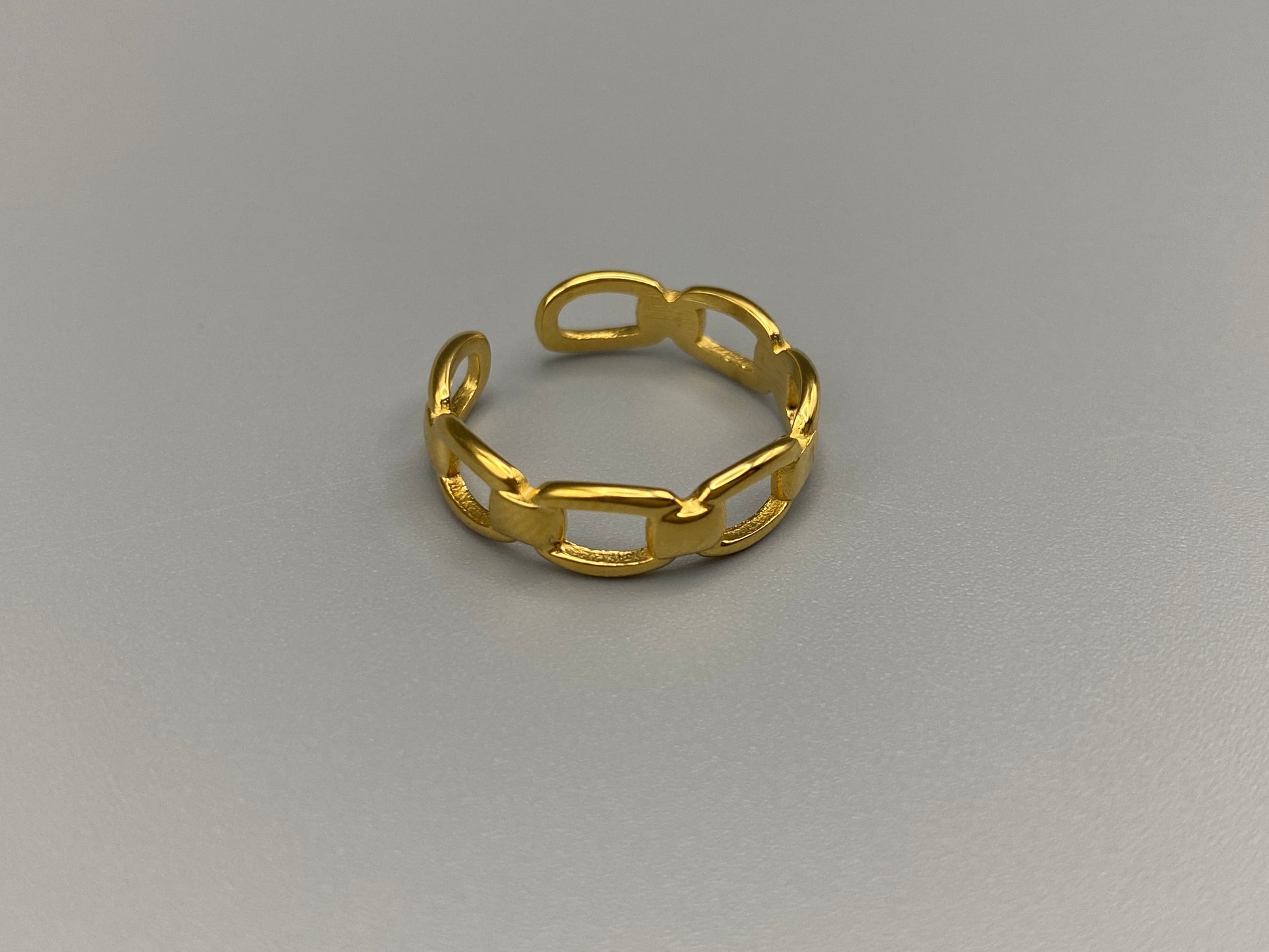 Phoebe Gold Ring: Discover the Phoebe Gold Ring, a fashionable and versatile piece perfect for any occasion. This 18K gold-plated stainless steel ring features a hollow geometric link chain design. It is resizable to size 6, making it a trendy and adaptable accessory. Ideal for daily wear or special events like anniversaries and parties, this ring is both nickel-free and lead-free, ensuring it is safe for all skin types.
